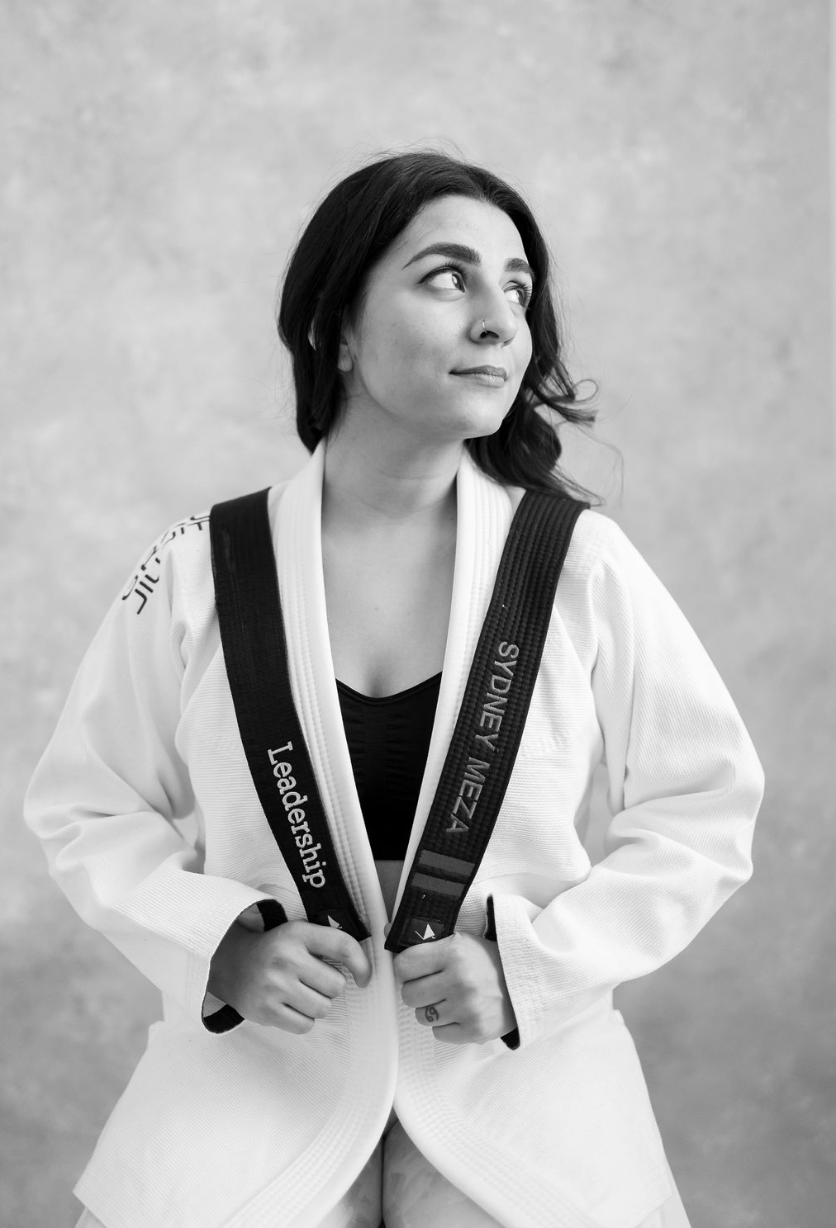 Sydney Meza in her martial arts uniform, holding her black belt